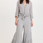 XCVI Lando Wide Leg Pants in soft pebble gray worn with matching tied blouse