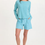 Woman wearing XCVI Elvio Shorts in mermaid tail pigment aqua blue with matching top