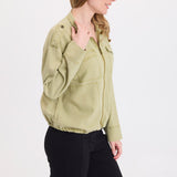 Woman wearing XCVI Tace Tencel Twill Relaxed Bomber Jacket in Artichoke Pigment with black pants