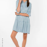 Bree Dress, Tencel lyocell dress, tiered mini dress, denim shirt dress, sustainable fashion, eco-friendly women's clothing, light blue chambray dress, tiered dress with pockets. at ooh la la! in Grapevine TX 76051
