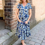 Dress Addict Jazy, organic cotton midi dress, blue floral dress with pockets, sustainable summer dress, bias cut v-neck dress, women's tiered floral midi, travel-friendly crinkle dress. at ooh la la! in Grapevine TX 76051