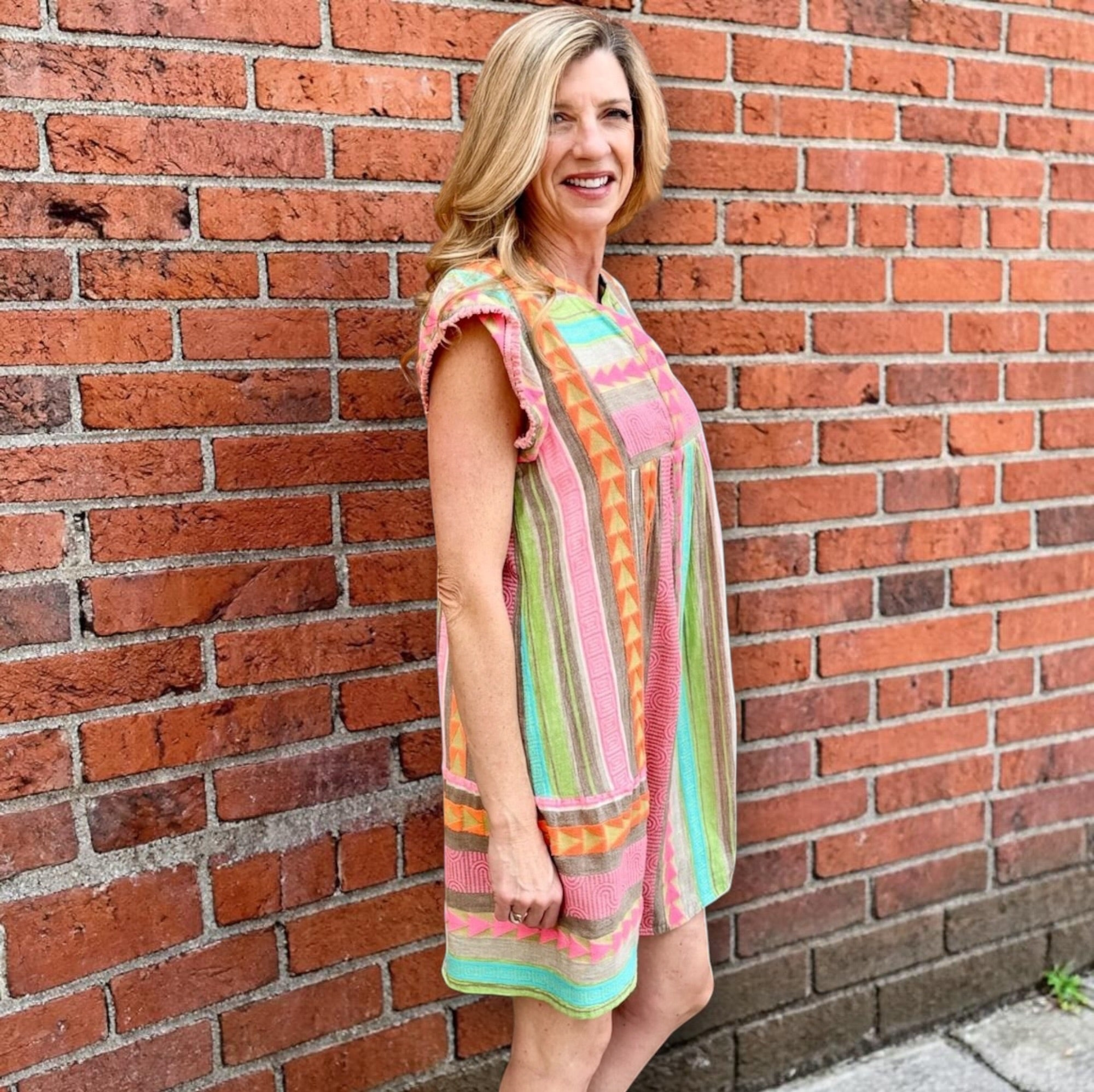Boho beach dress, neon summer dress, flutter sleeve mini, geometric print dress, tassel trim dress, resort wear for women, cotton v-neck dress, vacation outfits, colorful sun dress. at ooh la la! in Grapevine TX 76051