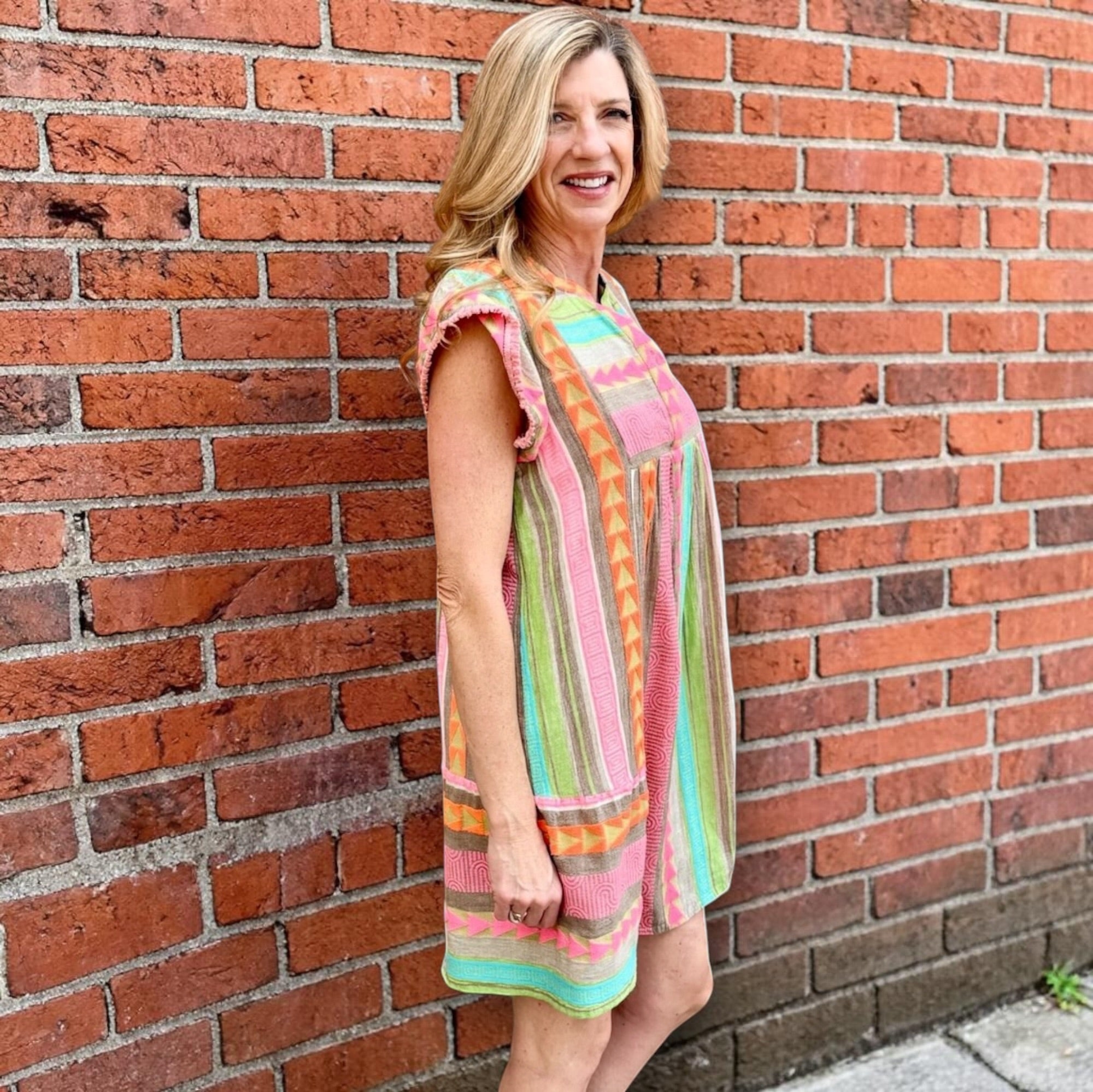 Boho beach dress, neon summer dress, flutter sleeve mini, geometric print dress, tassel trim dress, resort wear for women, cotton v-neck dress, vacation outfits, colorful sun dress. at ooh la la! in Grapevine TX 76051
