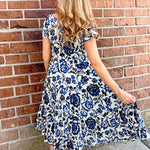 Dress Addict Jazy, organic cotton midi dress, blue floral dress with pockets, sustainable summer dress, bias cut v-neck dress, women's tiered floral midi, travel-friendly crinkle dress. at ooh la la! in Grapevine TX 76051