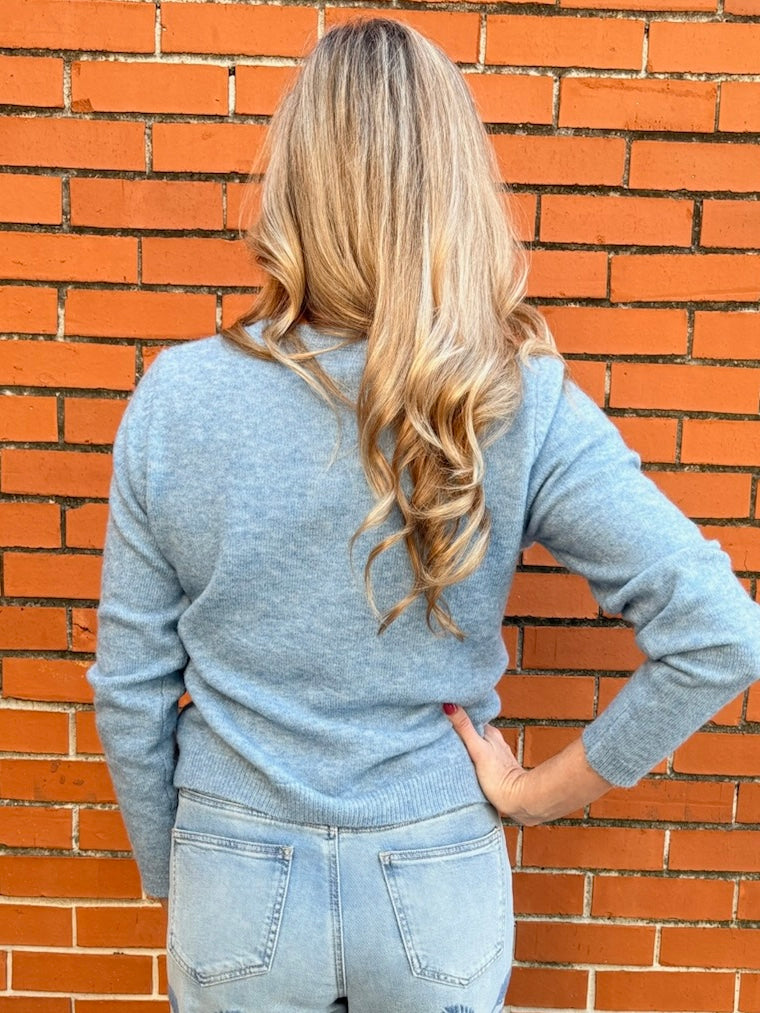 Light Blue soft knit cardigan, women's crewneck cardigan, button down sweater, pastel knitwear, lightweight layering piece, classic women's sweater, pearl button cardigan, spring knitwear staples.
at ooh la la in Grapevine TX 76051