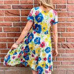 Dress Addict Jazy, organic cotton midi dress, multi color floral dress with pockets, sustainable summer dress, bias cut v-neck dress, women's tiered floral midi, travel-friendly crinkle dress. at ooh la la! in Grapevine TX 76051