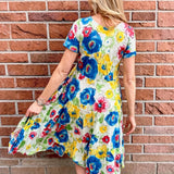 Dress Addict Jazy, organic cotton midi dress, multi color floral dress with pockets, sustainable summer dress, bias cut v-neck dress, women's tiered floral midi, travel-friendly crinkle dress. at ooh la la! in Grapevine TX 76051