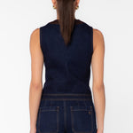 Back view of dark navy denim vest with brown leather trim and matching wide-leg jeans