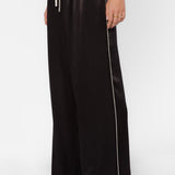 Black satin wide-leg pants with cream side piping and drawstring waist on model