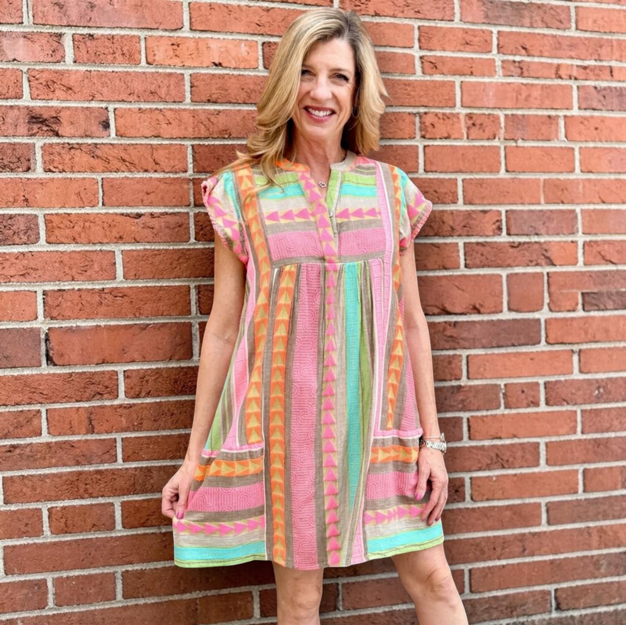 Boho beach dress, neon summer dress, flutter sleeve mini, geometric print dress, tassel trim dress, resort wear for women, cotton v-neck dress, vacation outfits, colorful sun dress. at ooh la la! in Grapevine TX 76051