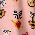 Close-up of PJ Salvage Love Lockets flannel print featuring hearts, bows, and lockets on pink background