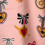 Close-up of PJ Salvage Love Lockets flannel print featuring hearts, bows, and lockets on pink background