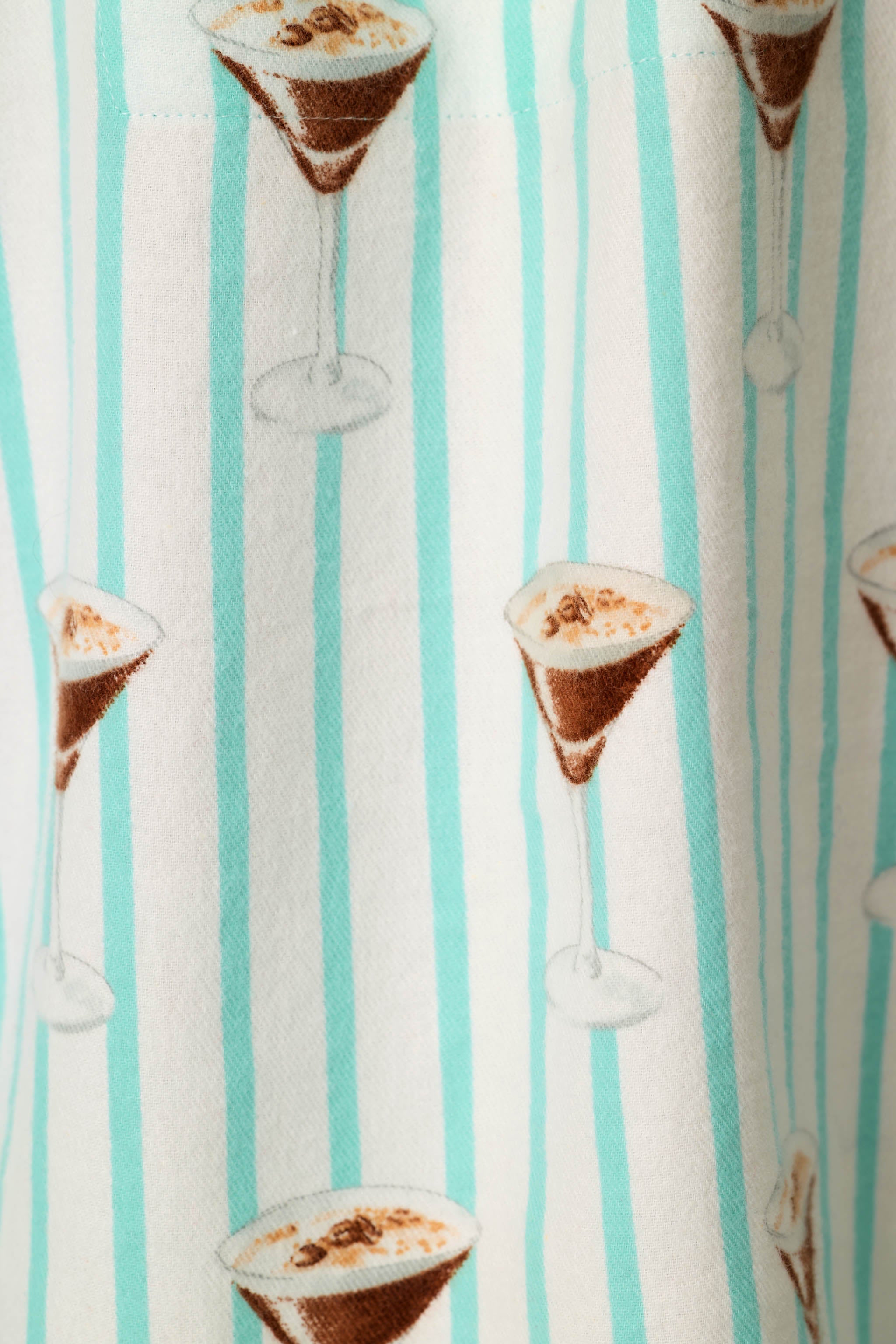Close-up of flannel fabric with espresso martini print on aqua striped pool blue background
