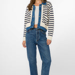 Woman wearing ivory blue striped cardigan jacket with denim vest and jeans