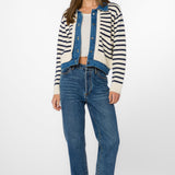 Woman wearing ivory blue striped cardigan jacket with denim vest and jeans