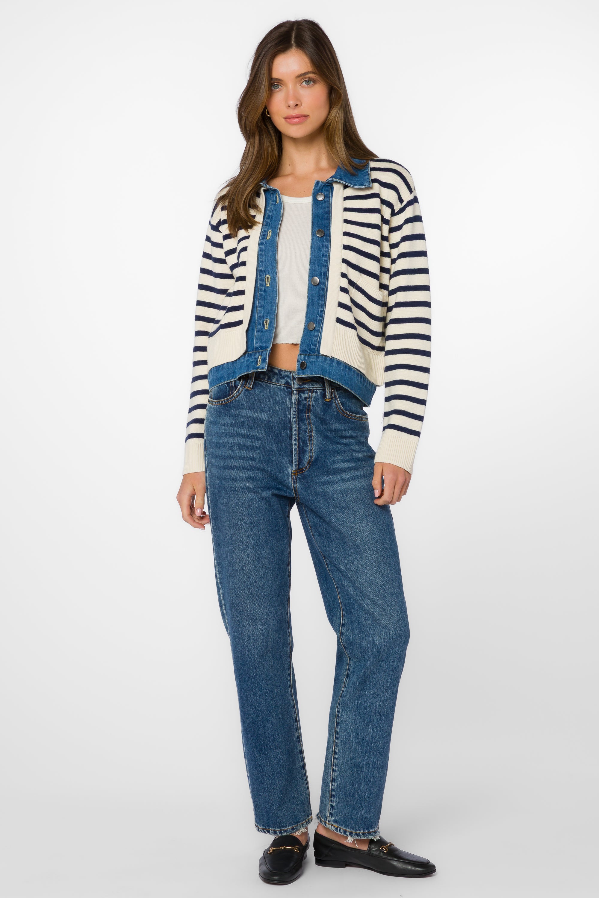 Woman wearing ivory blue striped cardigan jacket with denim vest and jeans