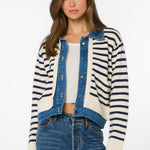Woman wearing ivory and navy striped cardigan jacket with denim blue trim