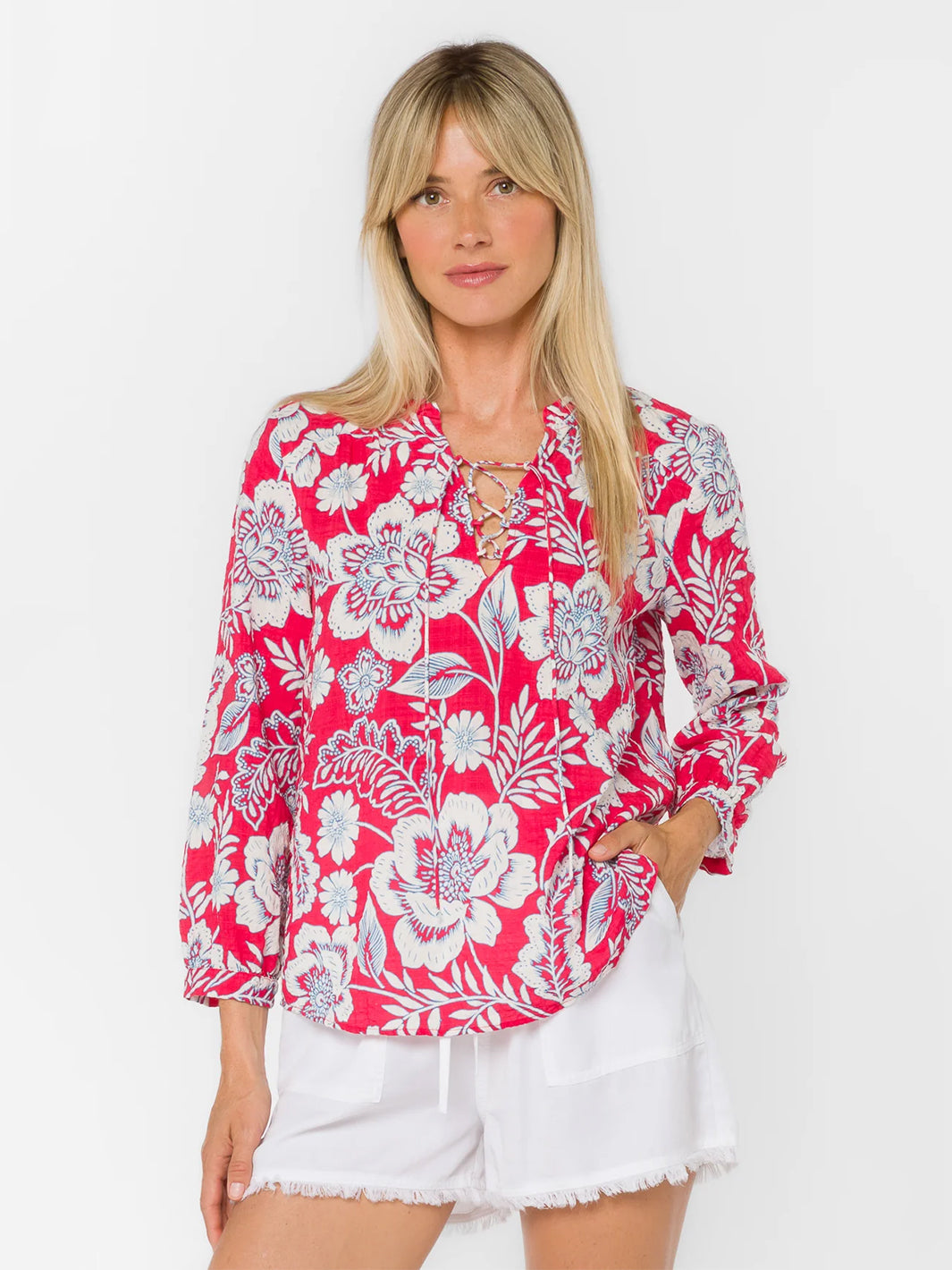 Woman wearing pink floral blouse with lace-up neckline and long sleeves