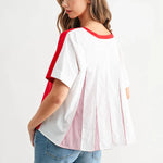 White blouse with red trim and pleated back detail worn with denim shorts