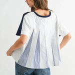 Woman wearing white tee with navy trim and blue striped pleat back detail