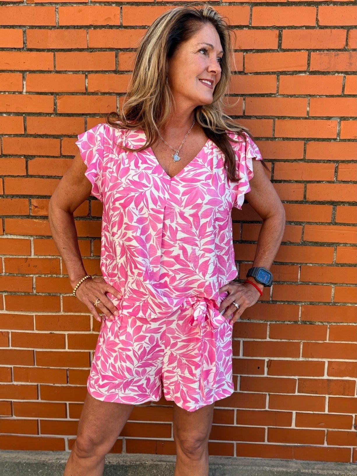 Flutter sleeve top, floral V-neck blouse, lightweight summer top, ruffled sleeve shirt, women’s botanical print top, pink floral blouse, breezy spring fashion. at ooh la la! in Grapevine TX 76051