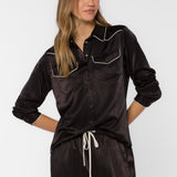 Woman wearing black satin western shirt with white contrast trim and snap buttons