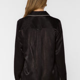 Back view of black satin shirt with white contrast trim on collar and cuffs