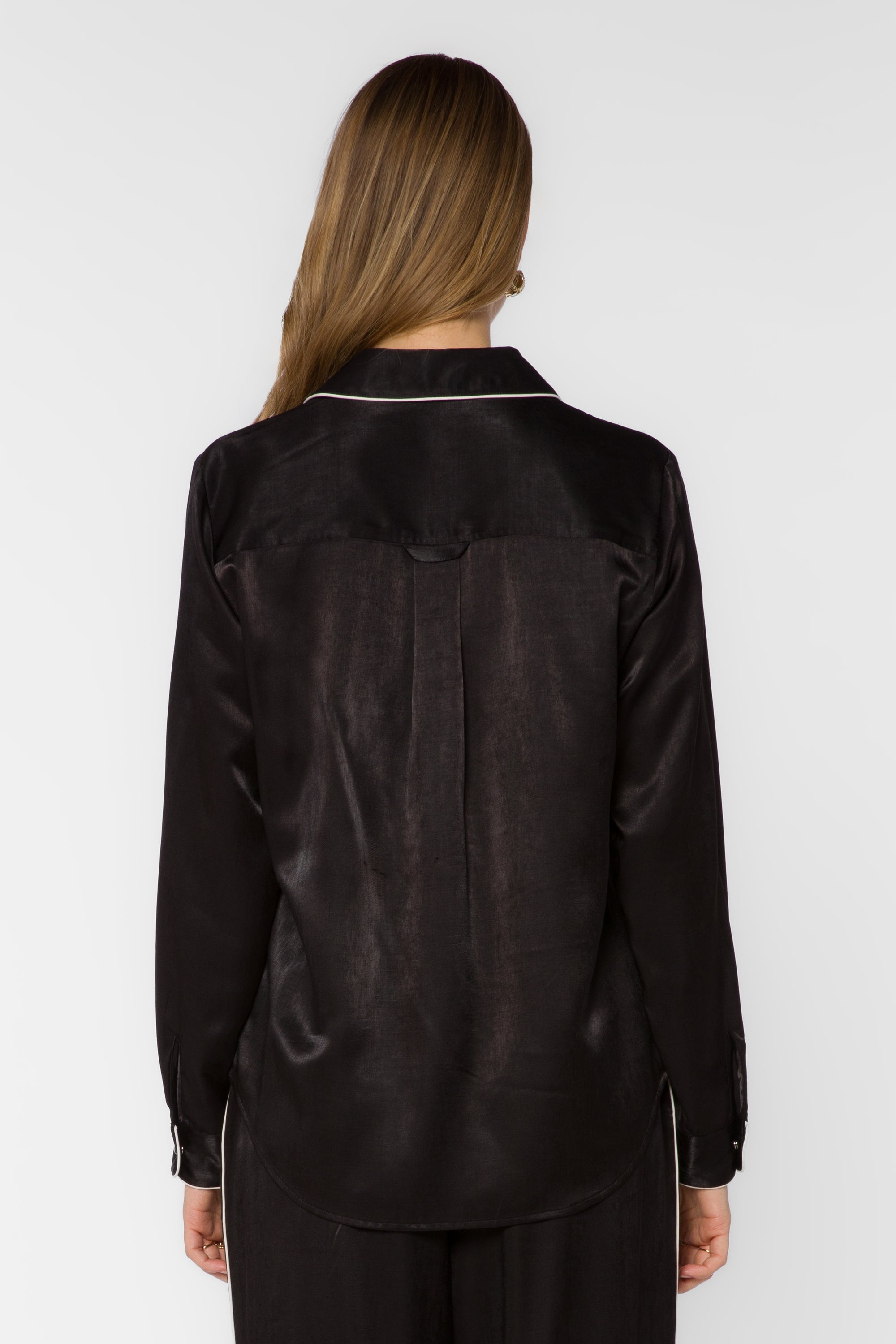 Back view of black satin shirt with white contrast trim on collar and cuffs