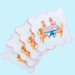 Set of four white scalloped cocktail napkins printed with poodles playing mahjong at a blue table