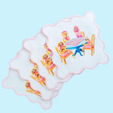 Set of four white scalloped cocktail napkins printed with poodles playing mahjong at a blue table