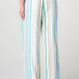 Woman wearing striped wide leg pull-on pants in cream, teal, and blue vertical stripes