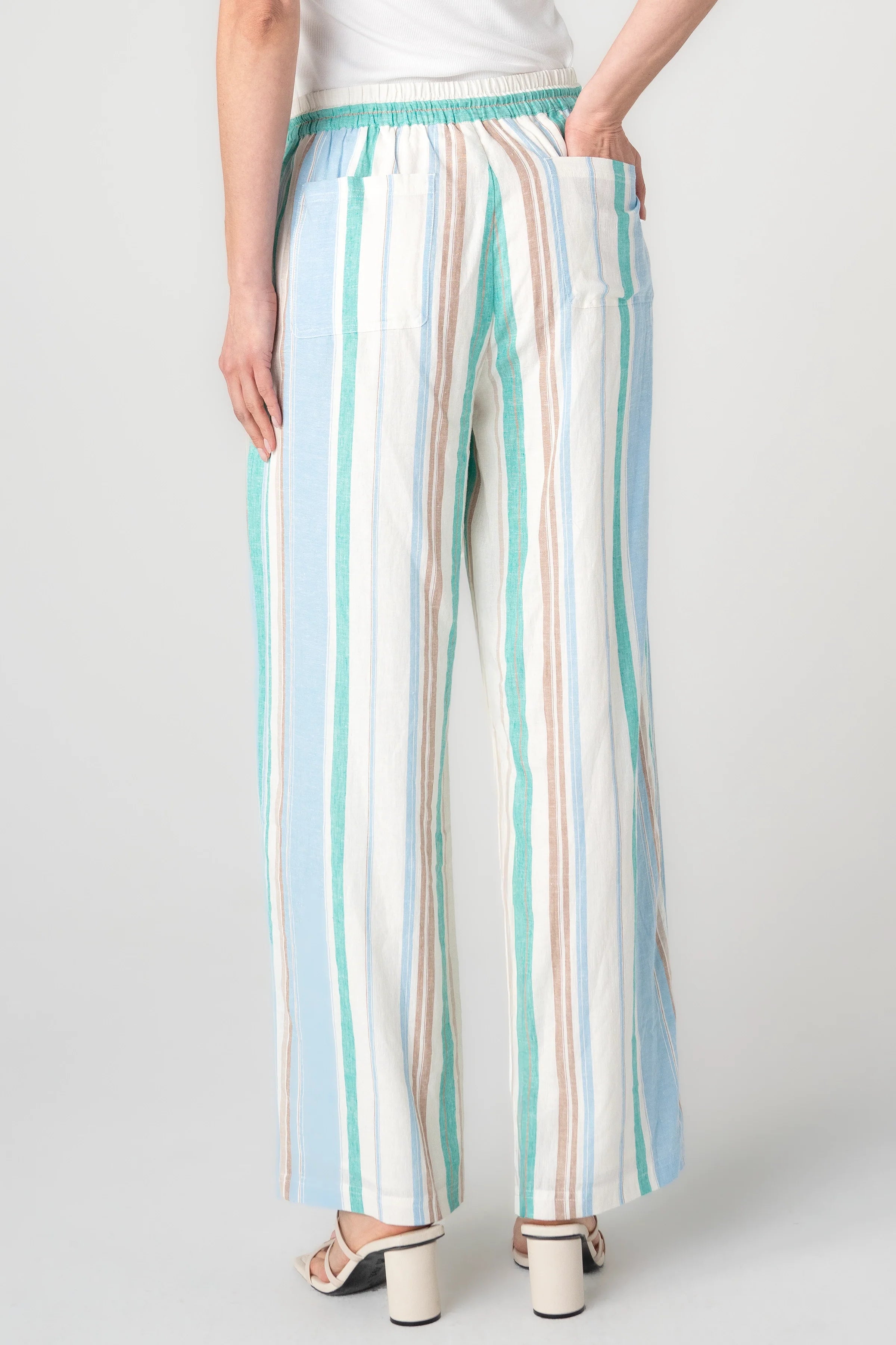 Woman wearing striped wide leg pull-on pants in cream, teal, and blue vertical stripes