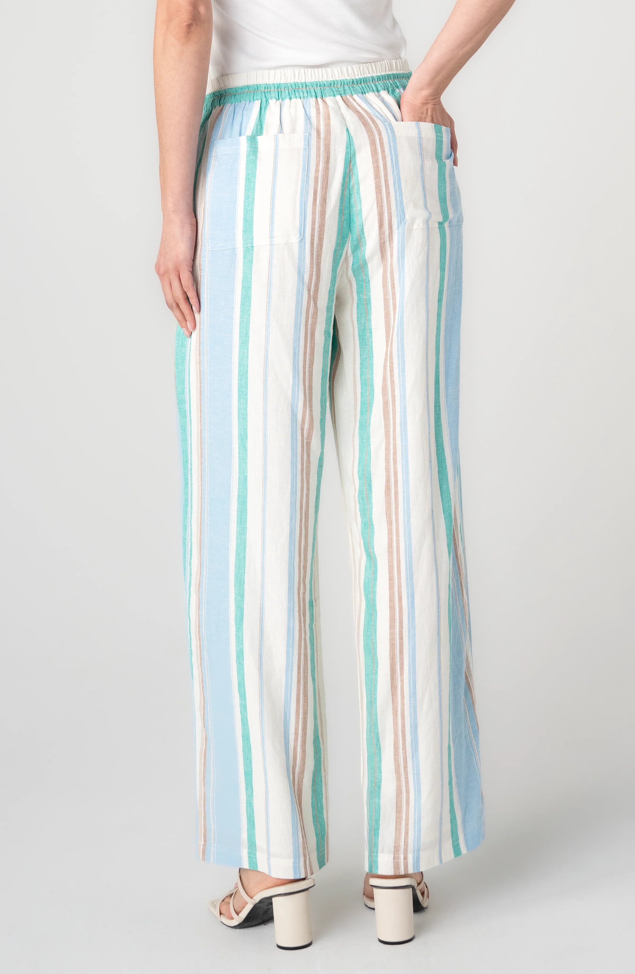 Woman wearing striped wide leg pull-on pants in cream, teal, and blue vertical stripes