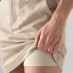 Woman wearing Liverpool utility skort in safari sand with cargo pocket detail
