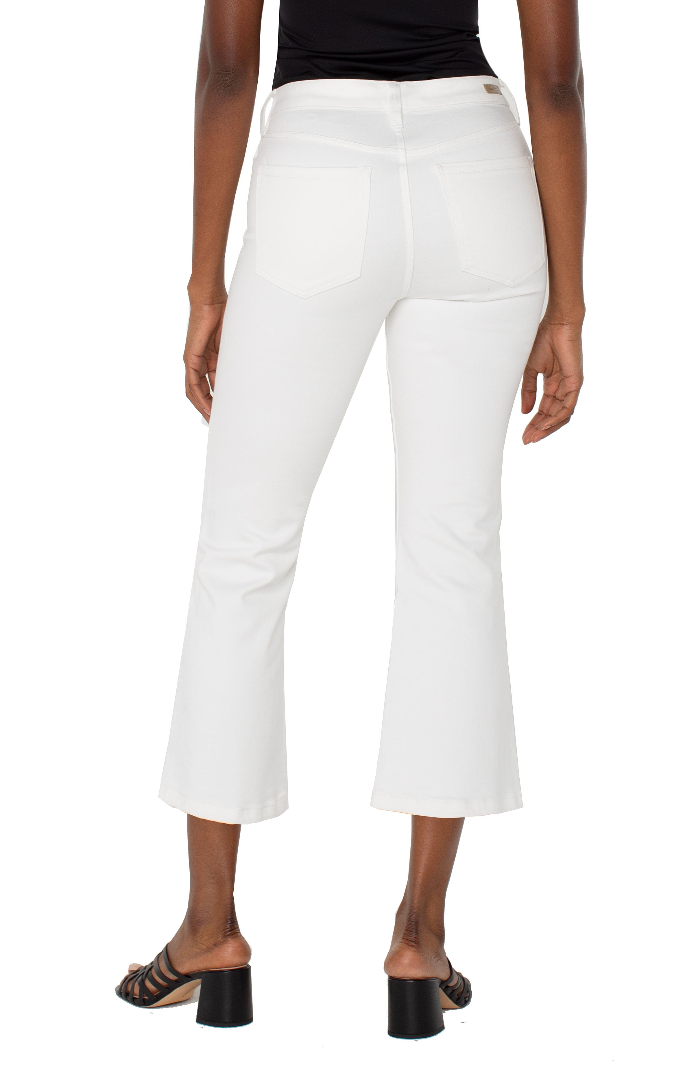 White crop flare jeans with twisted slit detail, back view on model