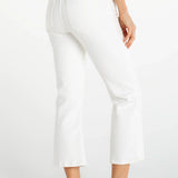 Woman wearing white cropped flare jeans with navy top and white sneakers