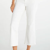 Woman wearing white cropped flare jeans with navy top and white sneakers