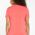 Women's short sleeve v-neck tee in sunset coral shown from the back view