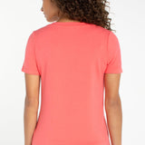 Women's short sleeve v-neck tee in sunset coral shown from the back view