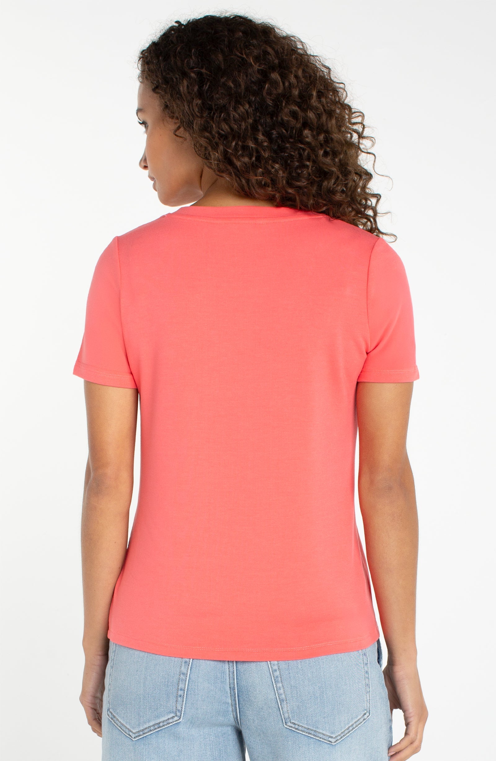 Women's short sleeve v-neck tee in sunset coral shown from the back view
