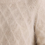 Close-up of a fuzzy boatneck sweater with scattered gold metallic sequin shimmer detail