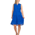 Woman wearing royal blue eyelet henley dress with tiered skirt and button front
