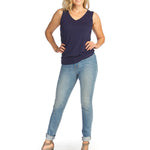 Woman wearing navy bamboo v-neck tank top with jeans on white background