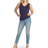 Woman wearing navy bamboo v-neck tank top with jeans on white background