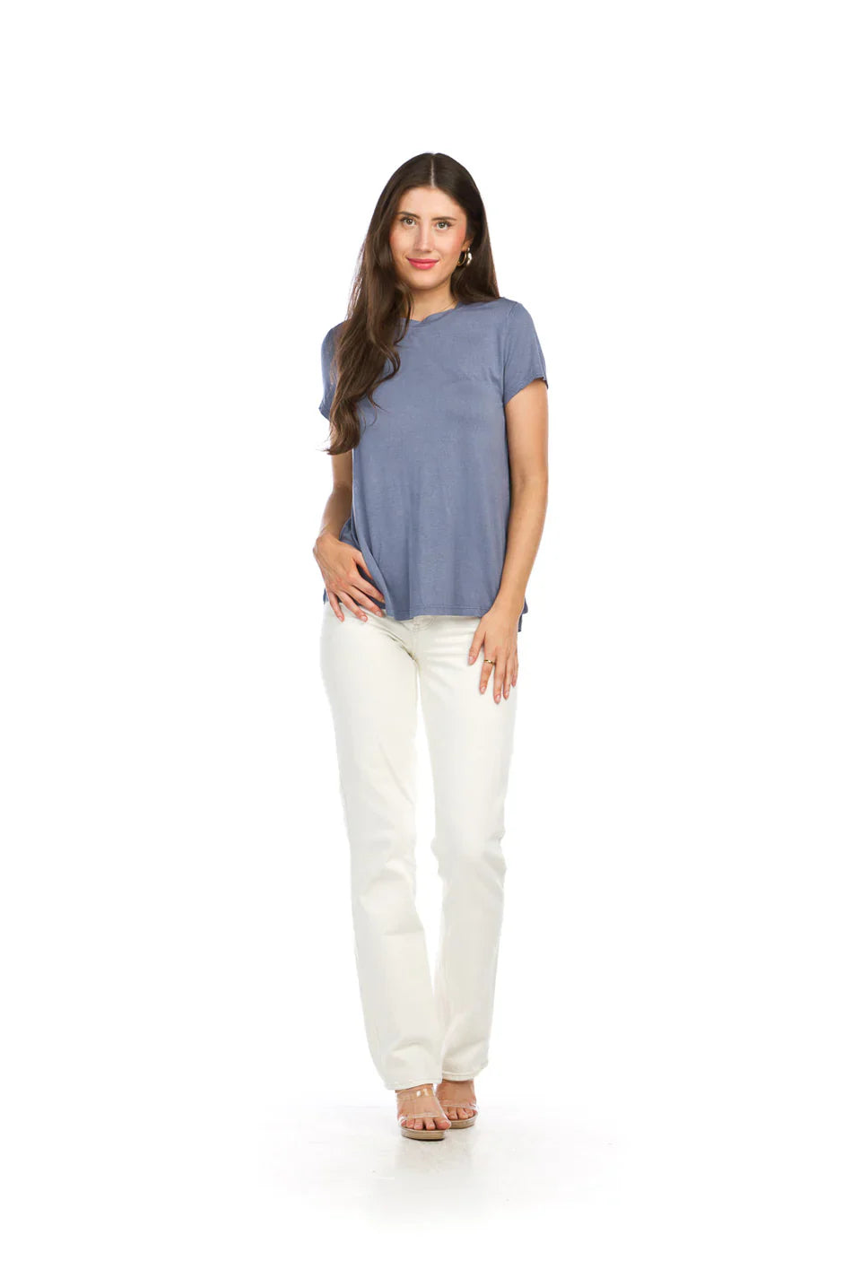 Woman wearing dusty blue bamboo tee with white pants on clean background