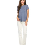 Woman wearing dusty blue bamboo tee with white pants on clean background
