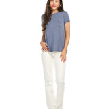 Woman wearing dusty blue bamboo tee with white pants on clean background