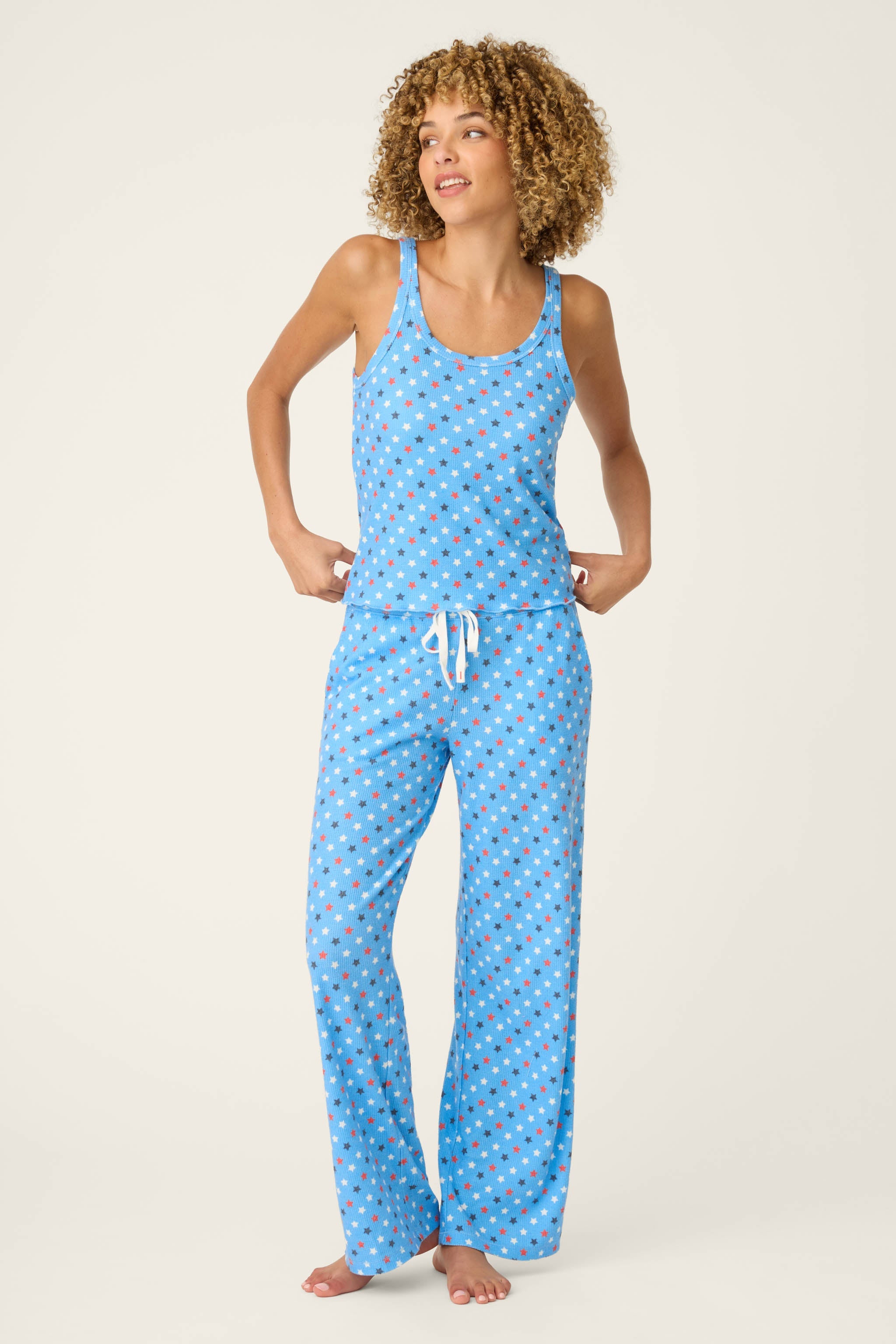Woman wearing bay blue star print camisole and matching pajama pants