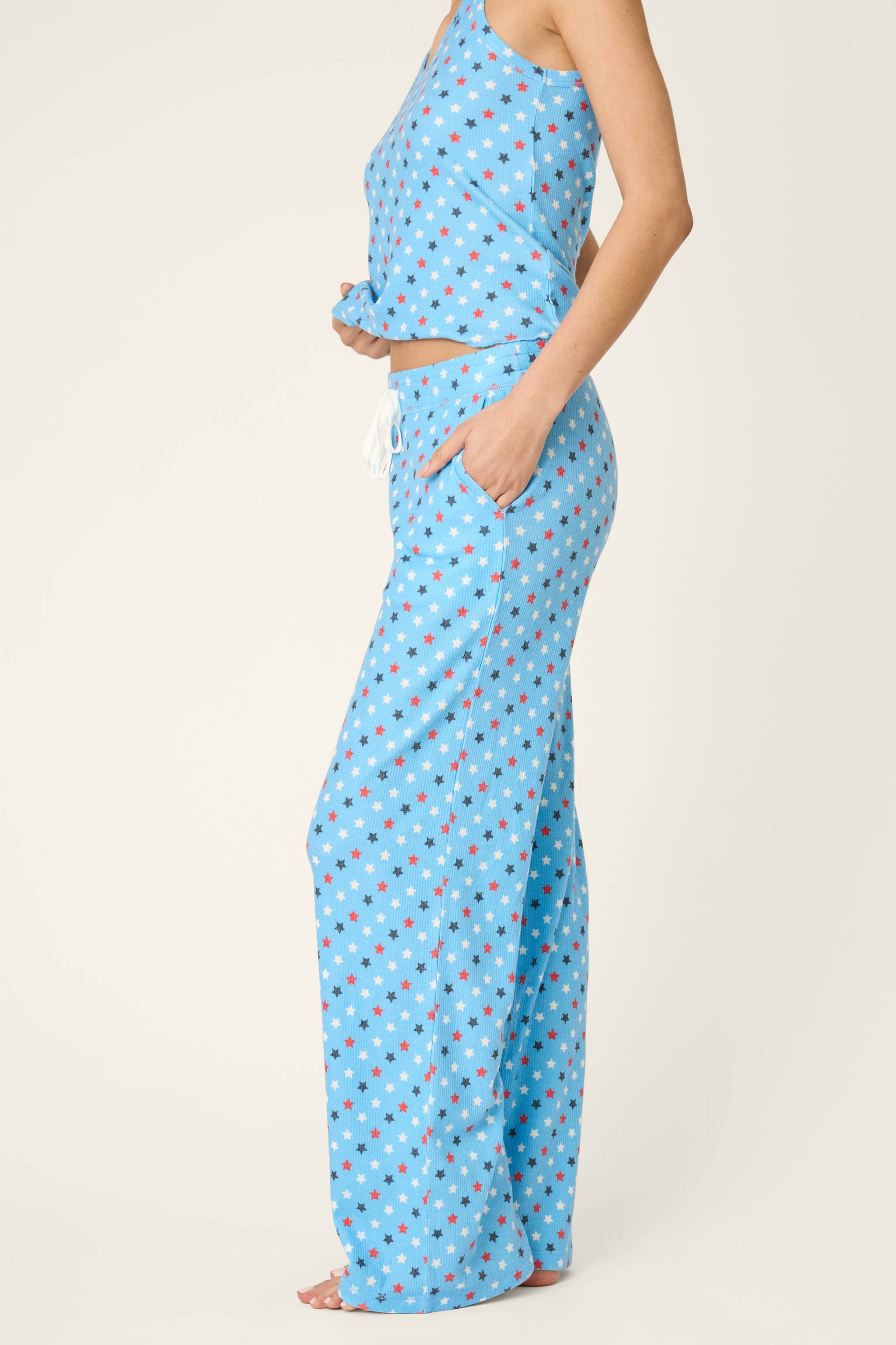 Woman wearing bay blue pajama set with patriotic star print pattern