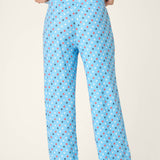 Light blue pajama pants with colorful star print pattern worn by model